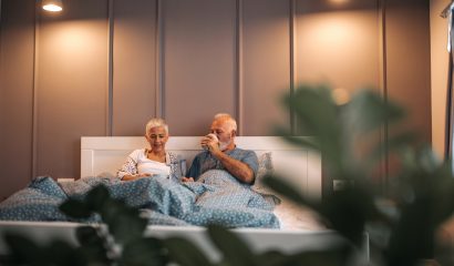 Senior couple drinking morning coffee in bed.