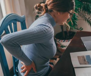 One young student studying at home and feeling bad pain in the back.