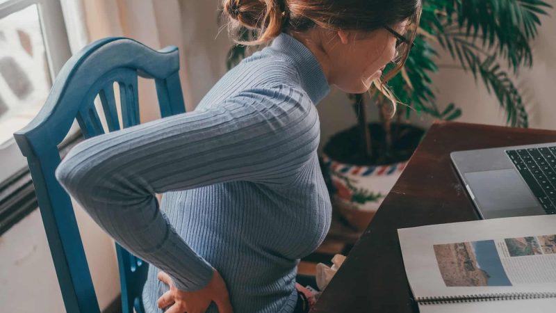 One young student studying at home and feeling bad pain in the back.