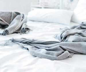 Sleep disorder, insomnia. Empty messy unmade bed. Cozy home textile in bedroom. Warmth and comfort.